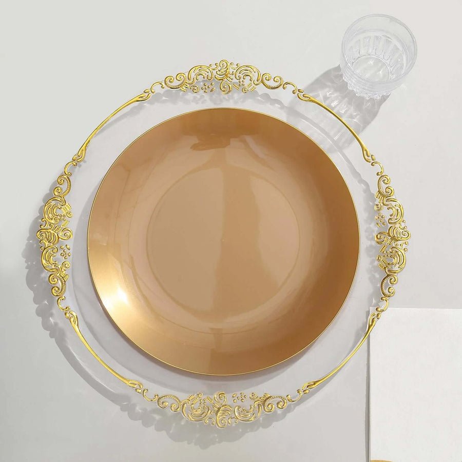 Clear baroque charger plate with ornate gold rim, set with dusty blue dinnerware. Elegant wedding decor.