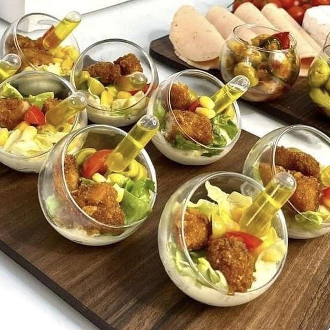 Acrylic sphere cups with salad appetizers and pipettes for dressing