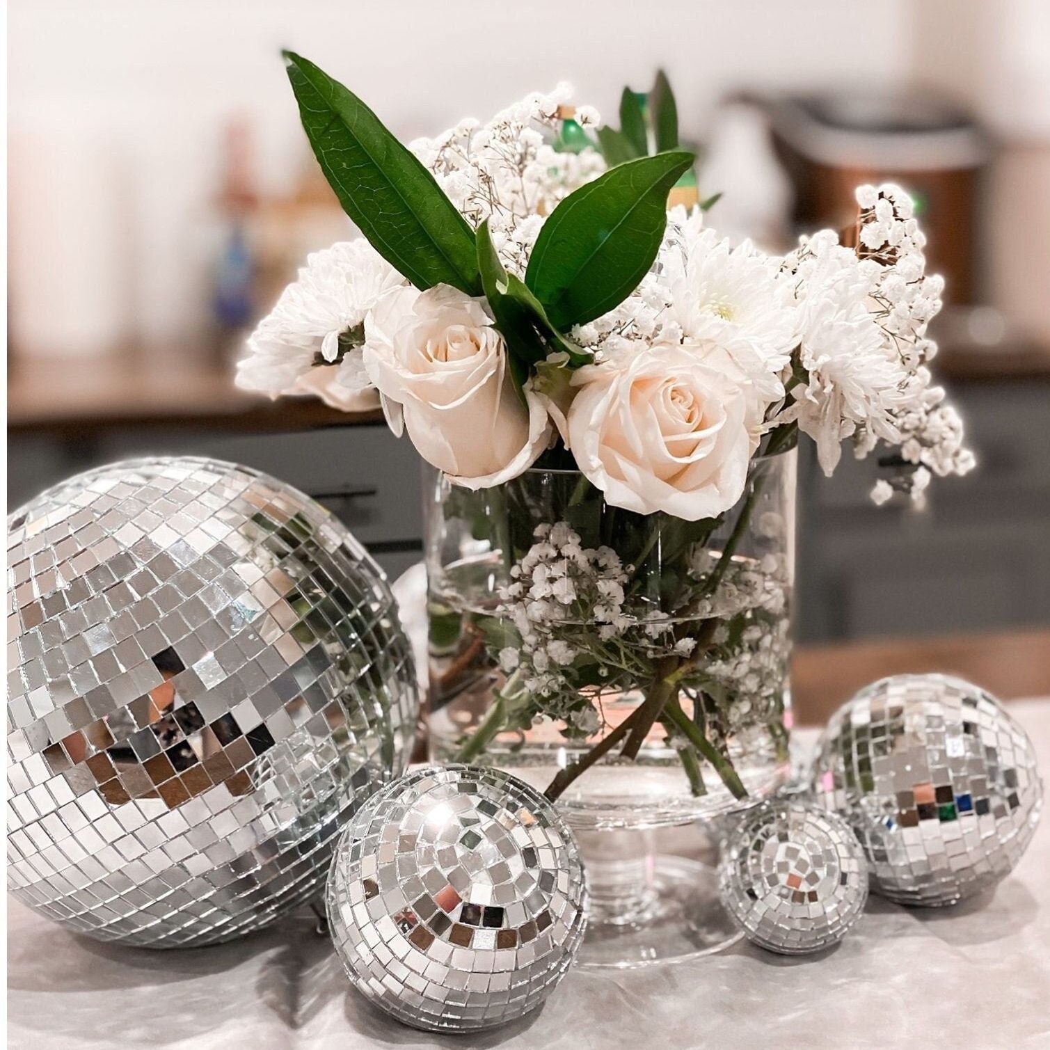 Assorted silver mirror disco balls adding sparkle to a bridal shower tablescape.
