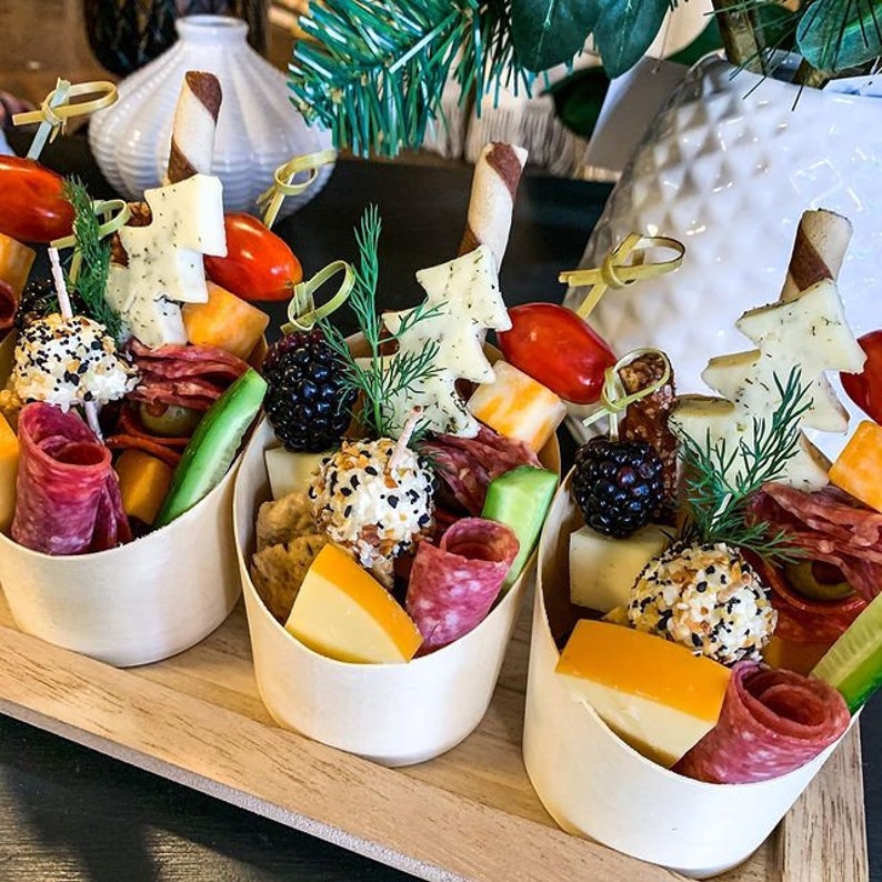 Bamboo charcuterie cups filled with meats, cheeses, and fruits