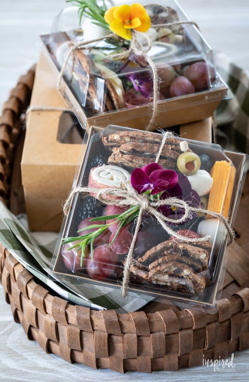 Elegant square charcuterie gift box with fresh fruit crackers and floral decoration
