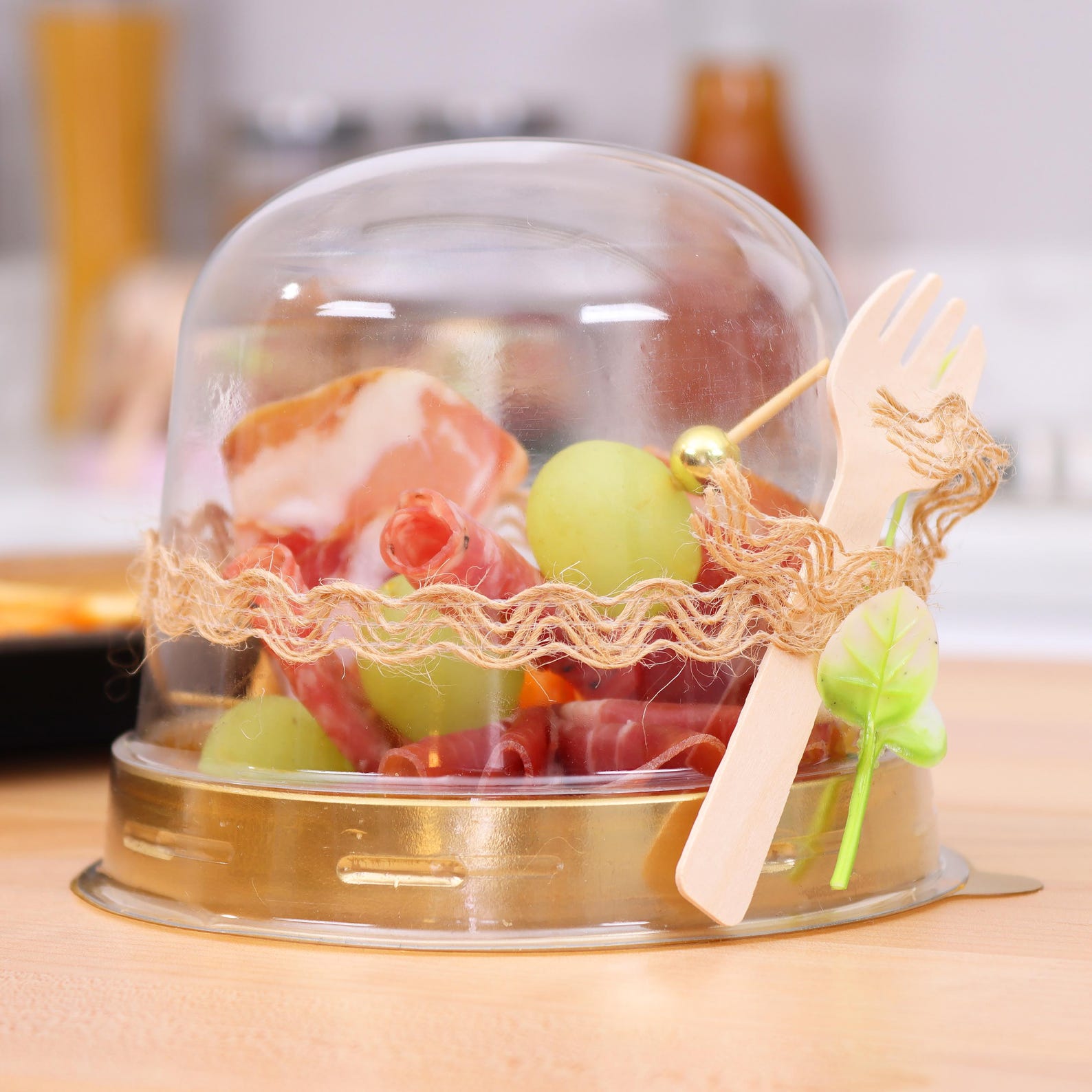 Clear plastic charcuterie domes arranged on a bridal shower grazing table.