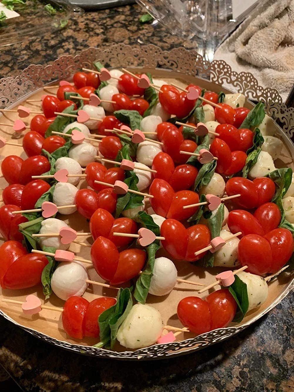 Charcuterie board with cherry tomatoes and cheese served on red heart fancy toothpicks