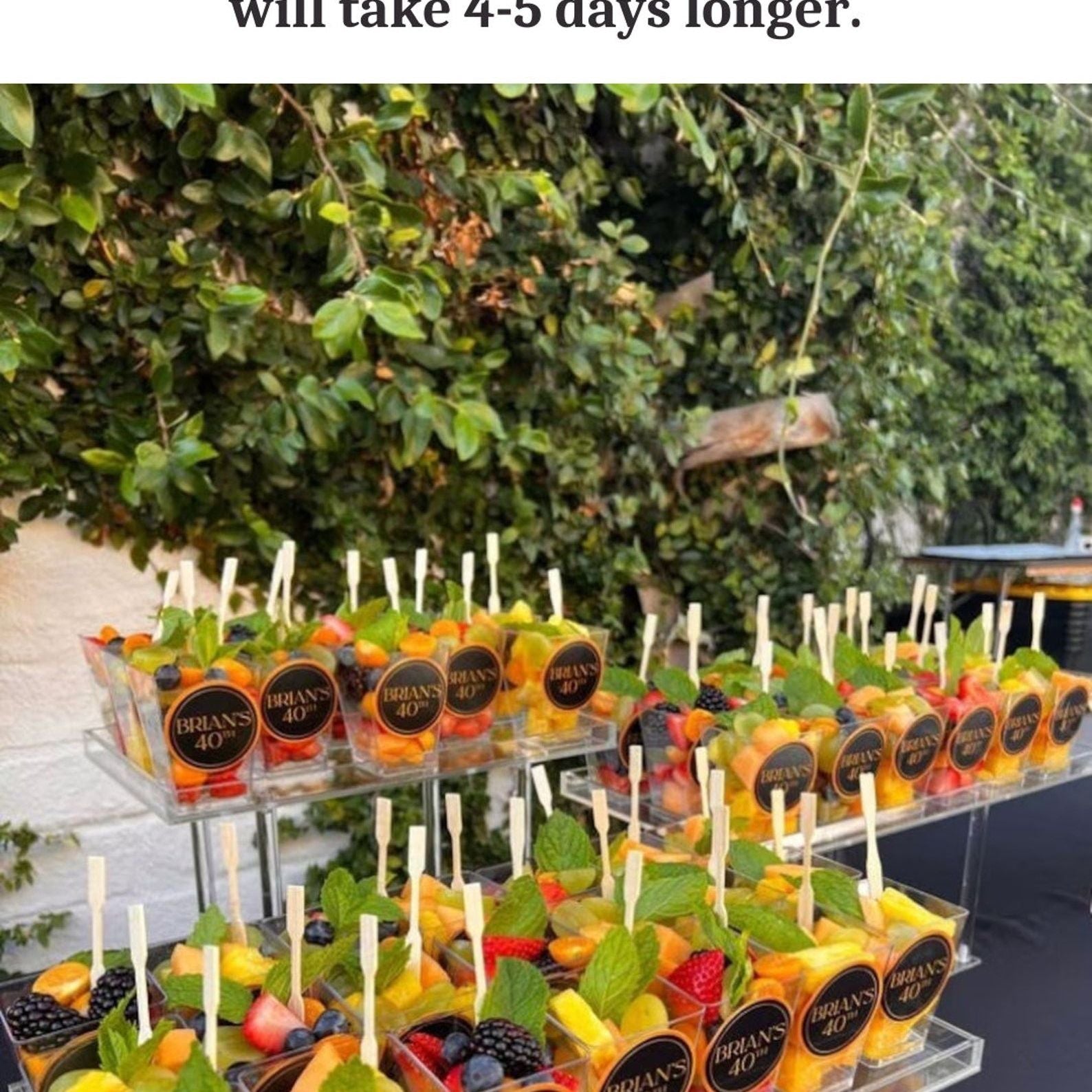 Charcuterie cups arranged with meats, cheese, and fruits.
