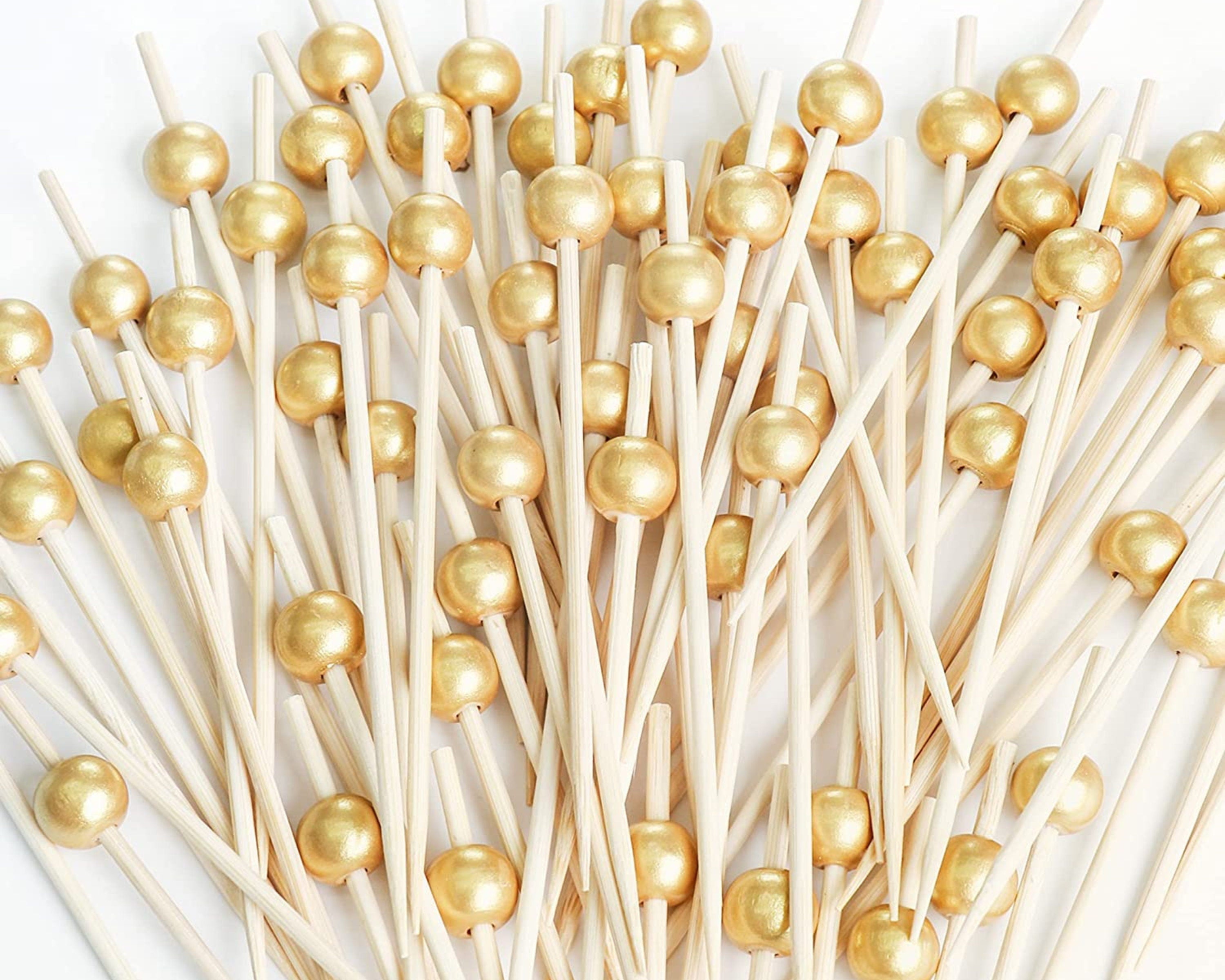 Close-up of premium gold bead fancy toothpicks bundled together, perfect for elegant charcuterie and appetizer presentations.