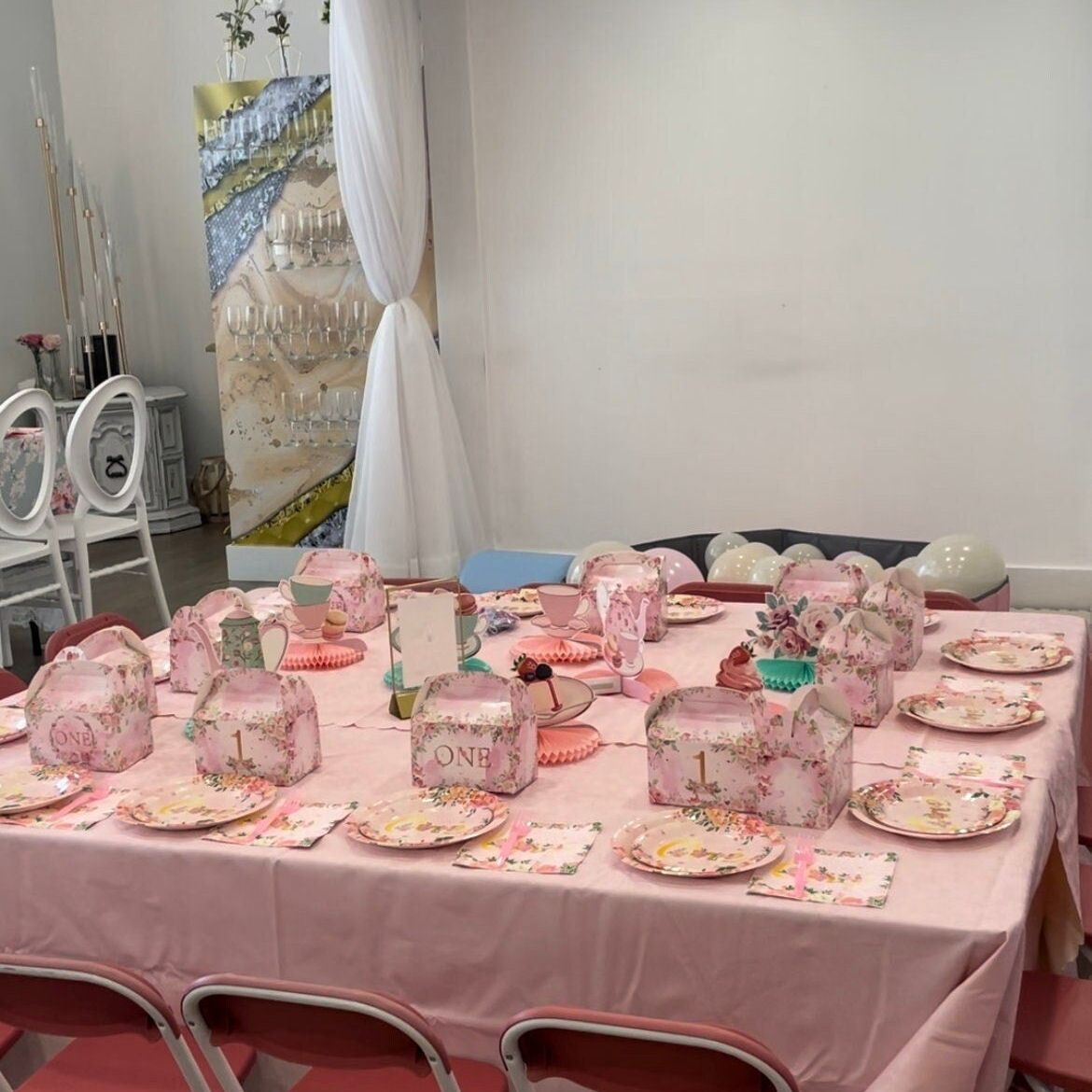 Complete first birthday party sets with coordinated tableware and pink balloon decorations