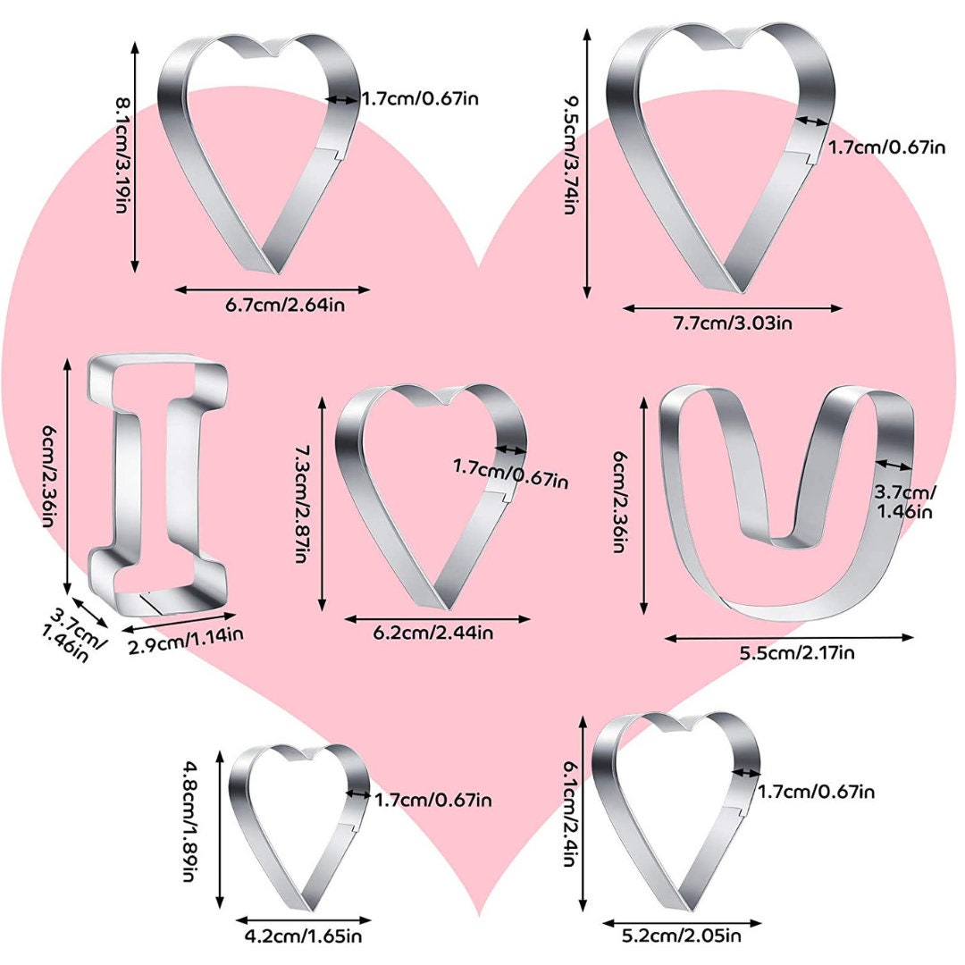 Heart-shaped cookie cutters cutting dough on a countertop.
