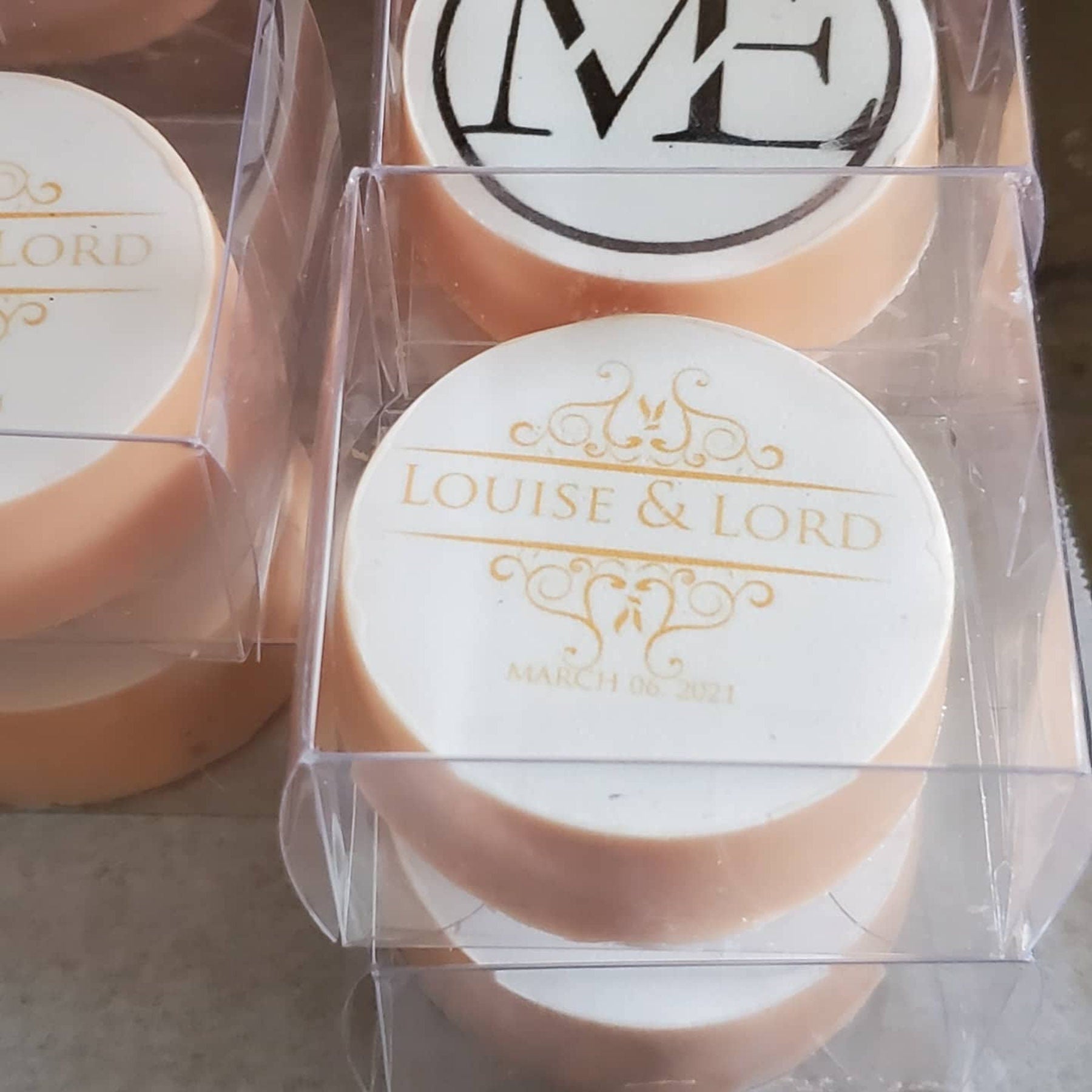 Stack of round desserts inside clear single-serve macaron boxes with custom labels
