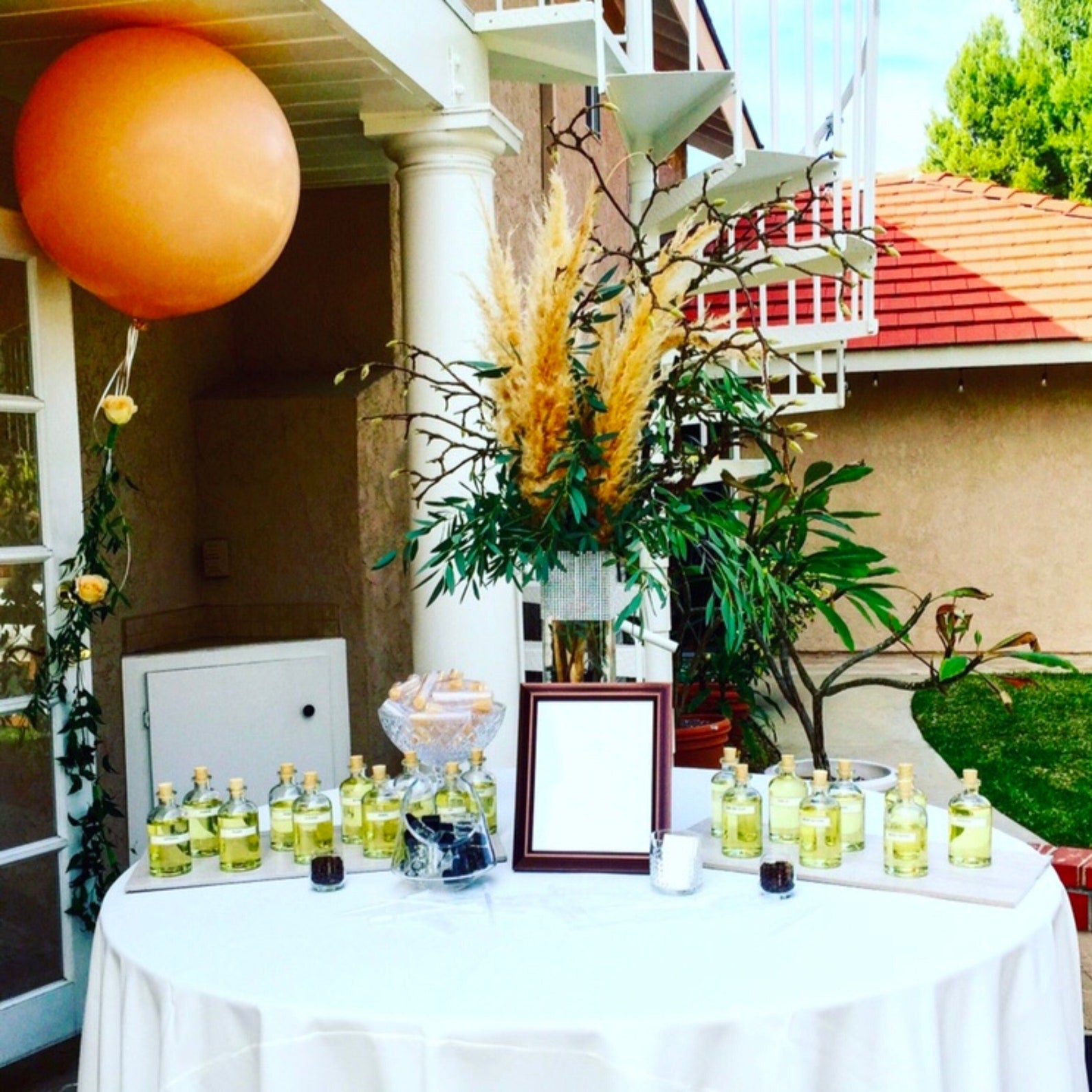 Outdoor event setup showing a custom men’s cologne bar with multiple fragrance bottles, droppers, and decor, designed for bachelor parties, weddings, or groomsmen proposal experiences where guests create their own cologne.