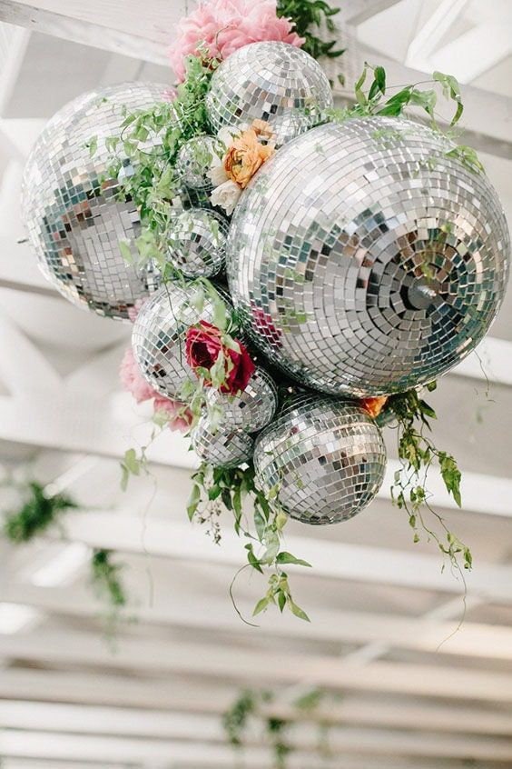 Silver disco balls decorated with greenery and flowers for hanging décor