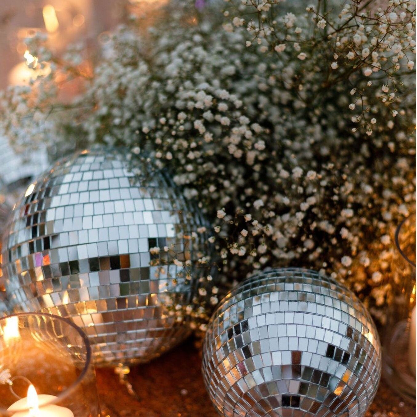 Hanging silver mirror disco balls adding sparkle to a bridal shower setup.