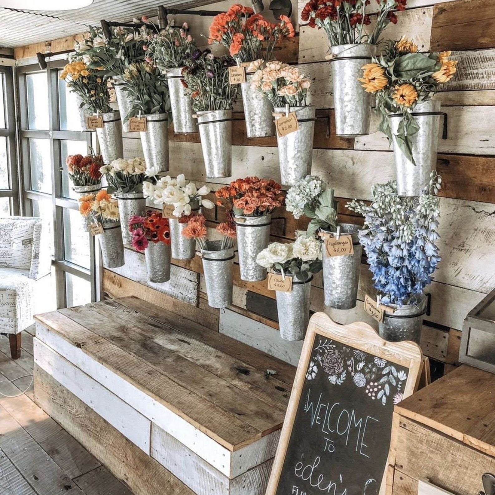 Display of flower bouquet bar supplies, including vintage tin buckets and wrapping options.