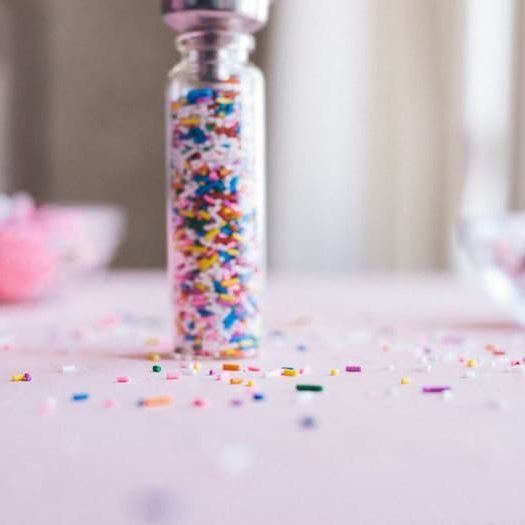 Fully assembled sprinkle bottle favors with colorful sprinkles.