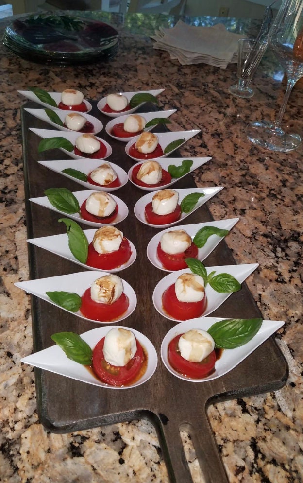 Grazing table display with tasting spoons and appetizers.