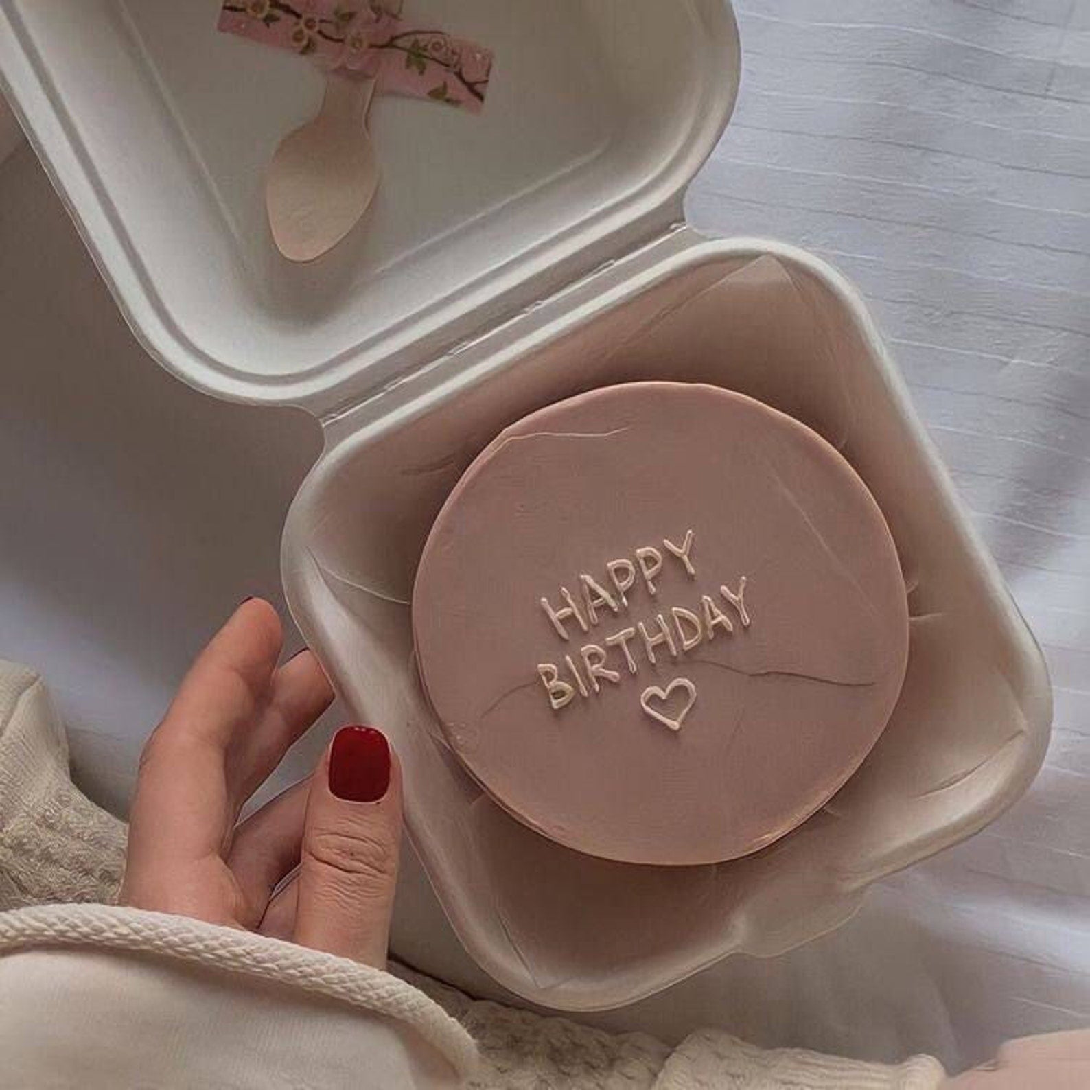 Round cake with "Happy Birthday" design inside a kraft cake gift box.