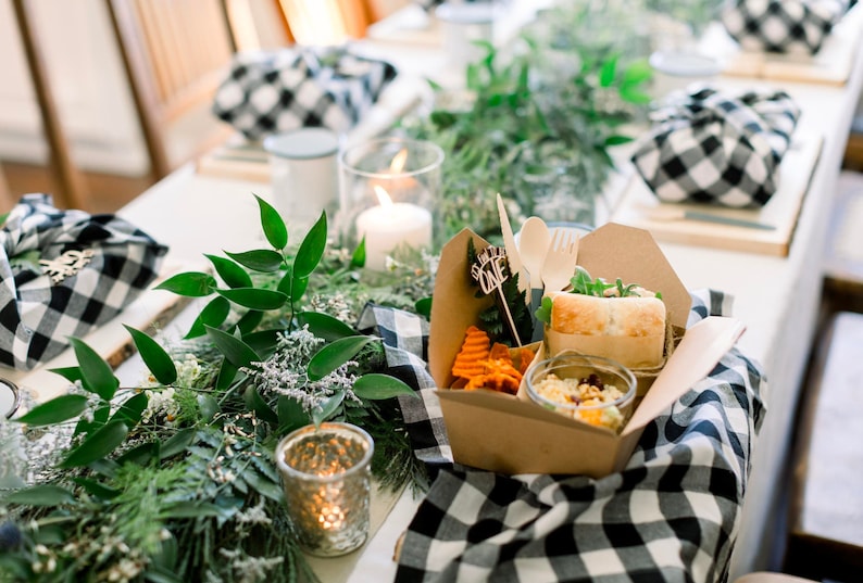 White takeout container beside kraft brown paper box showing eco-friendly catering options for weddings.