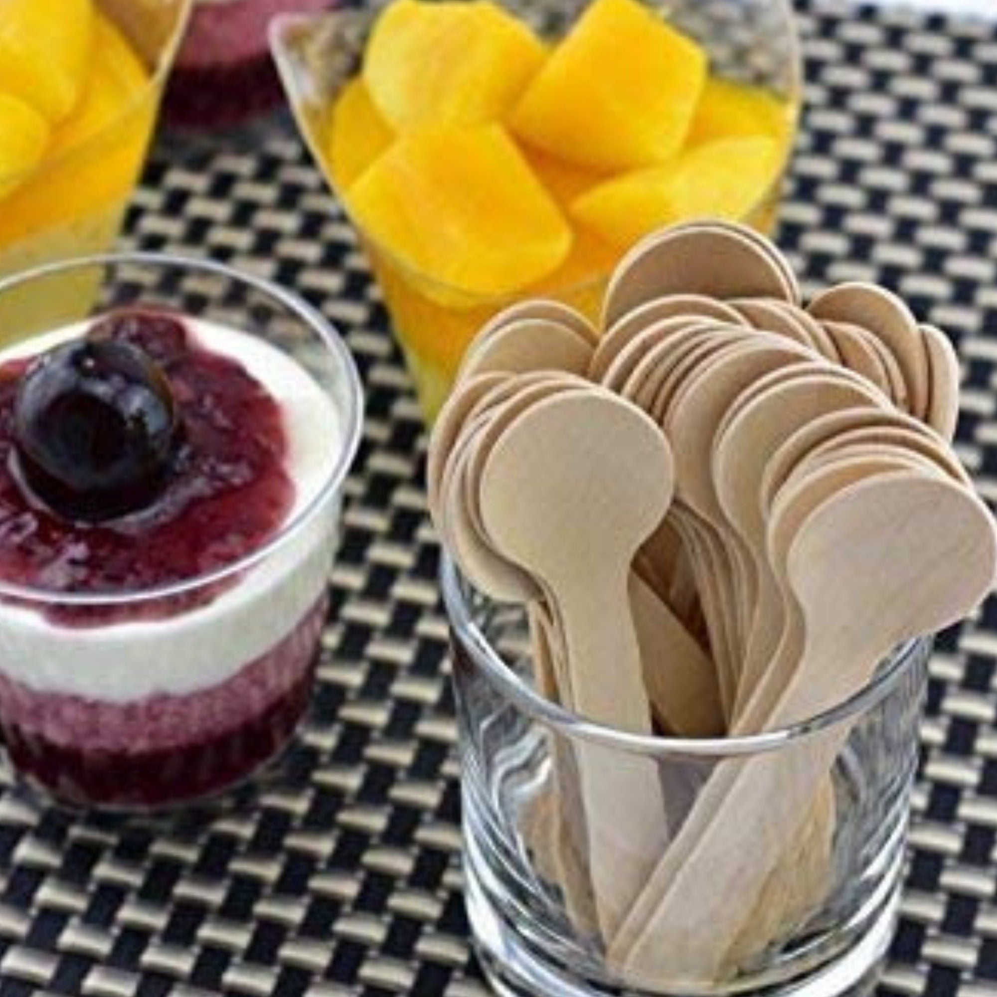 Wooden spoons in a glass cup for desserts and tastings