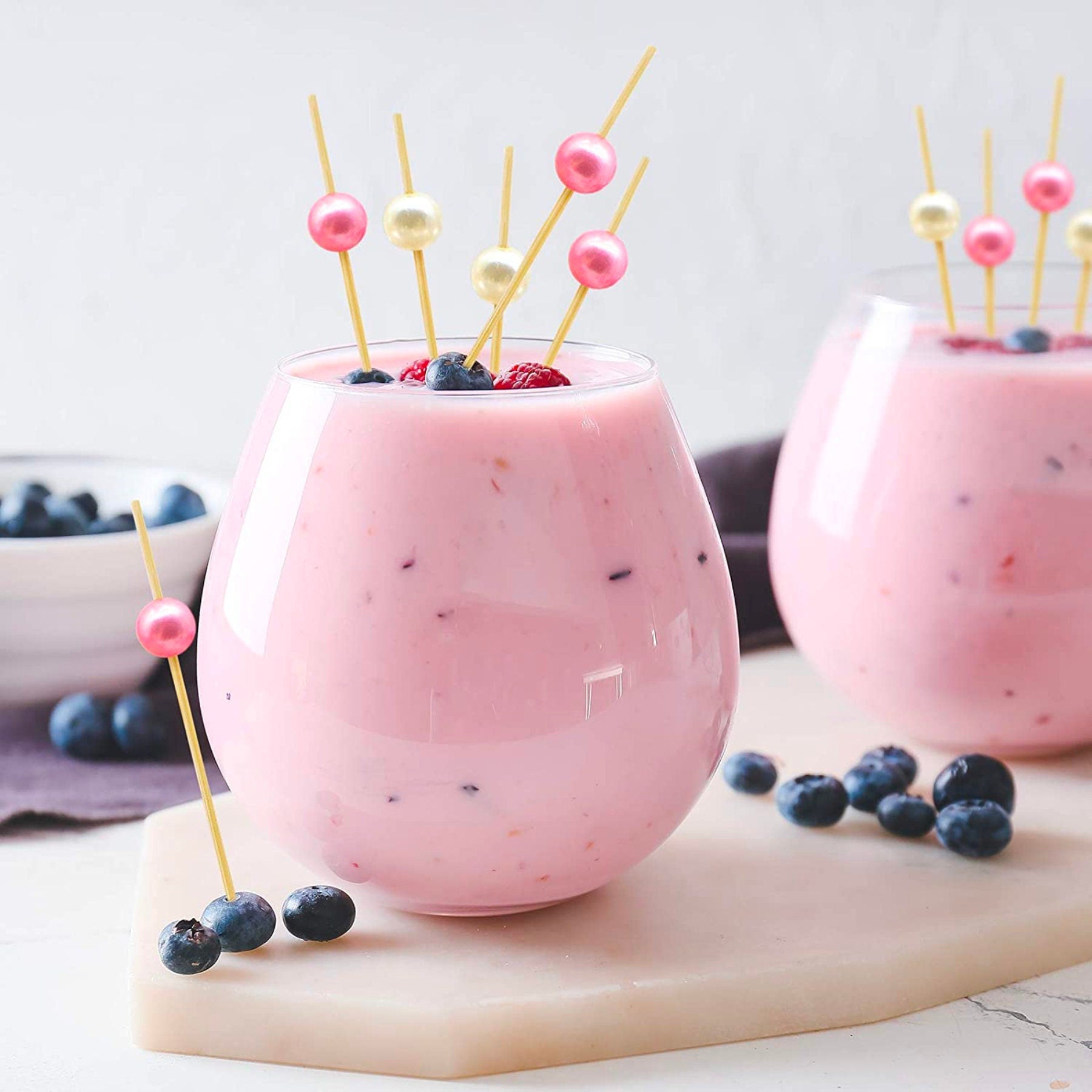 Pink charcuterie cocktail toothpicks used as drink and fruit garnish