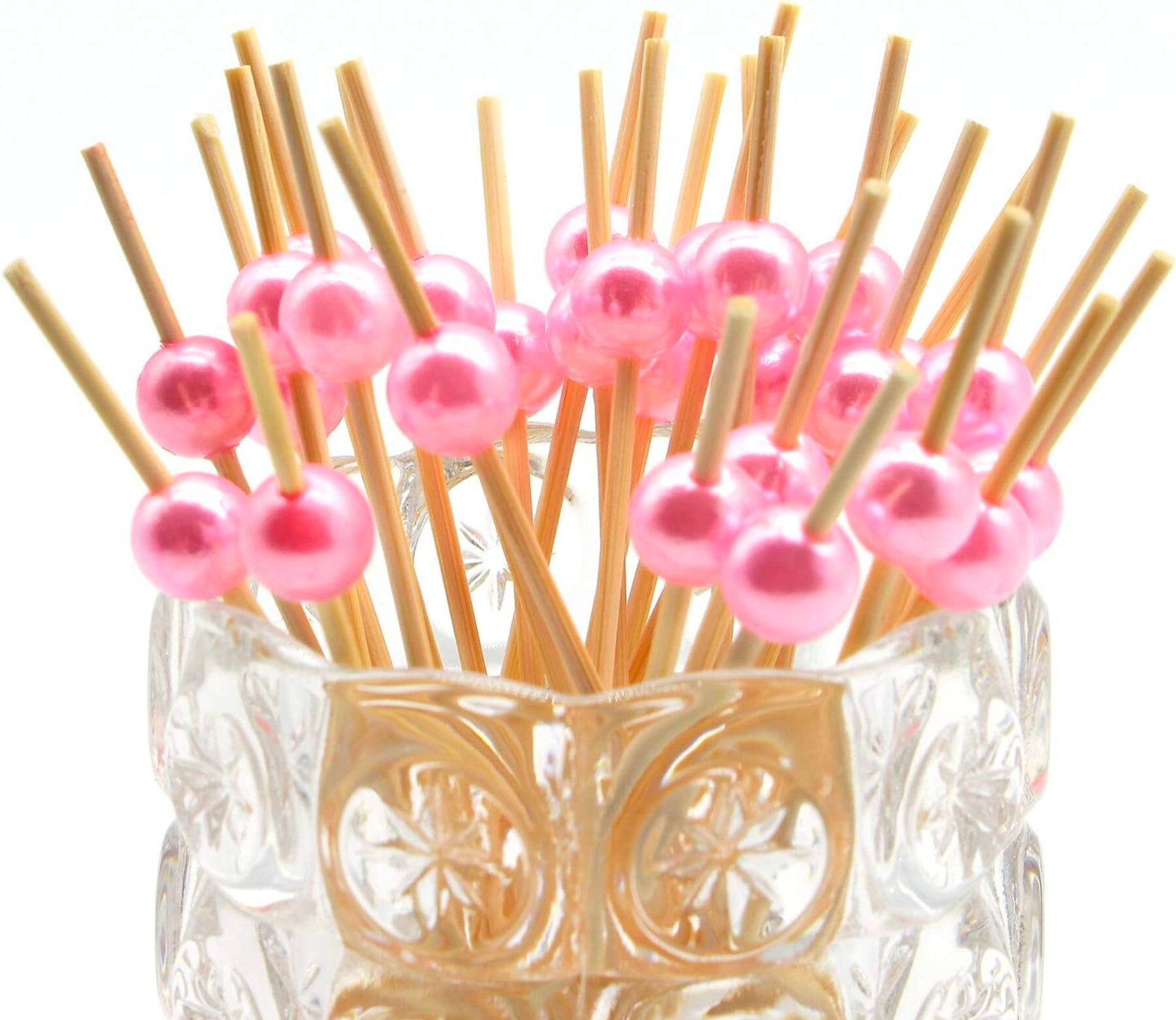 Pink fancy appetizer toothpicks displayed in clear holder for parties