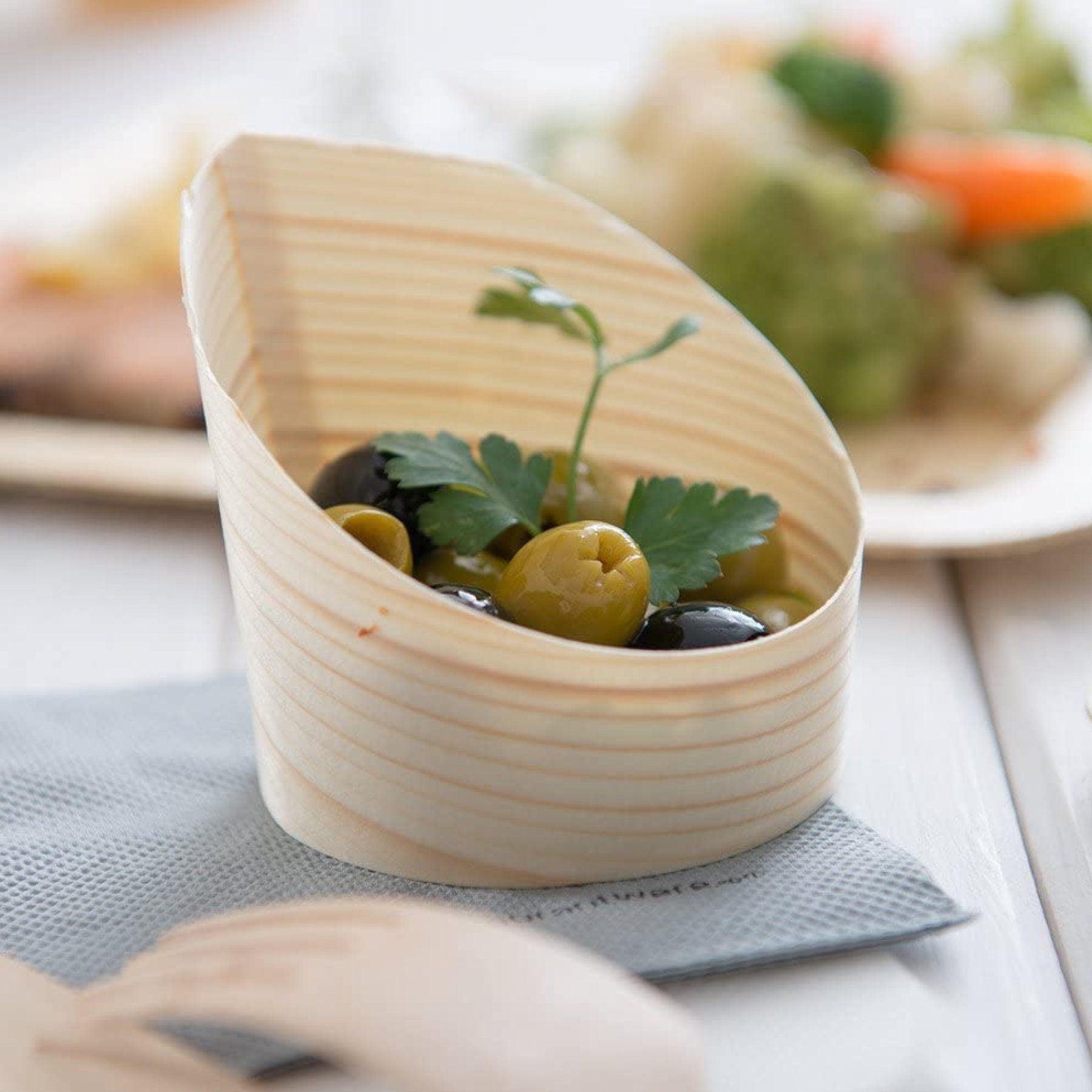 Close-up view of single bamboo cup showing 4 oz capacity and natural wood grain texture