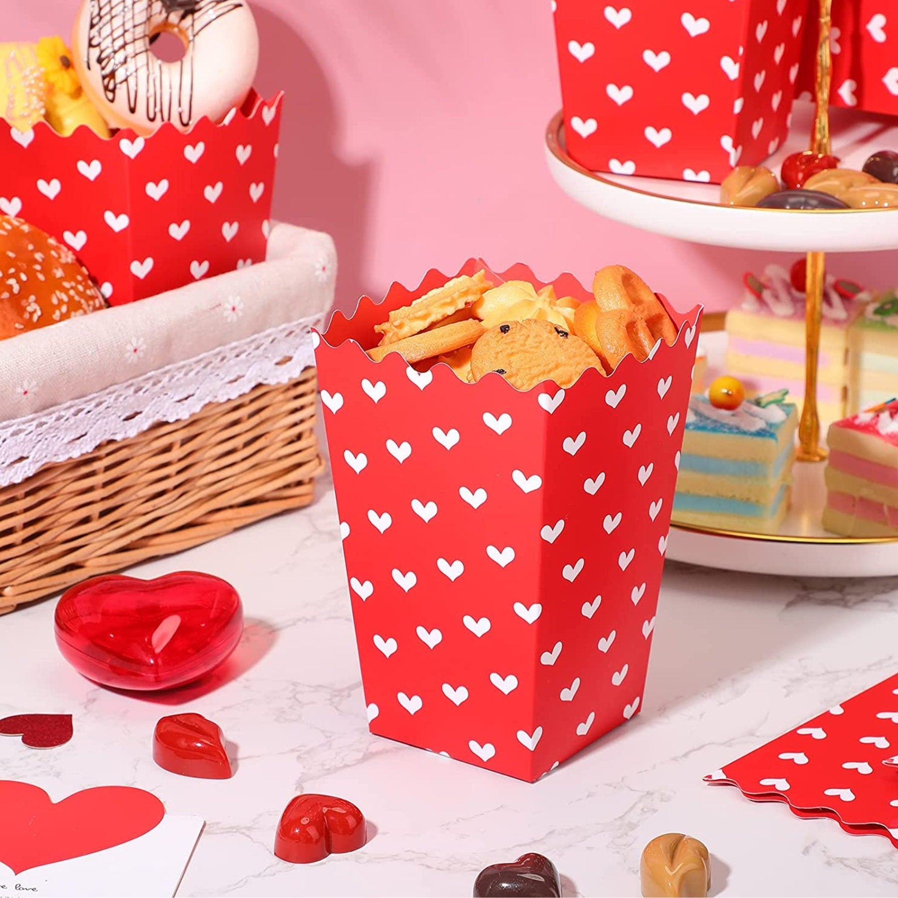 Single red heart design popcorn box displayed on decorated party table setting for festive celebrations and events.
