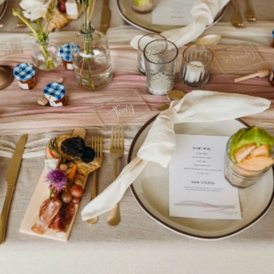 Wedding tablescape featuring small wooden charcuterie board at each place