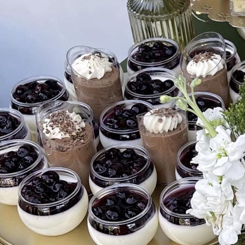 Multi-shelf stand displaying mini desserts in clear round bowls with floral accents