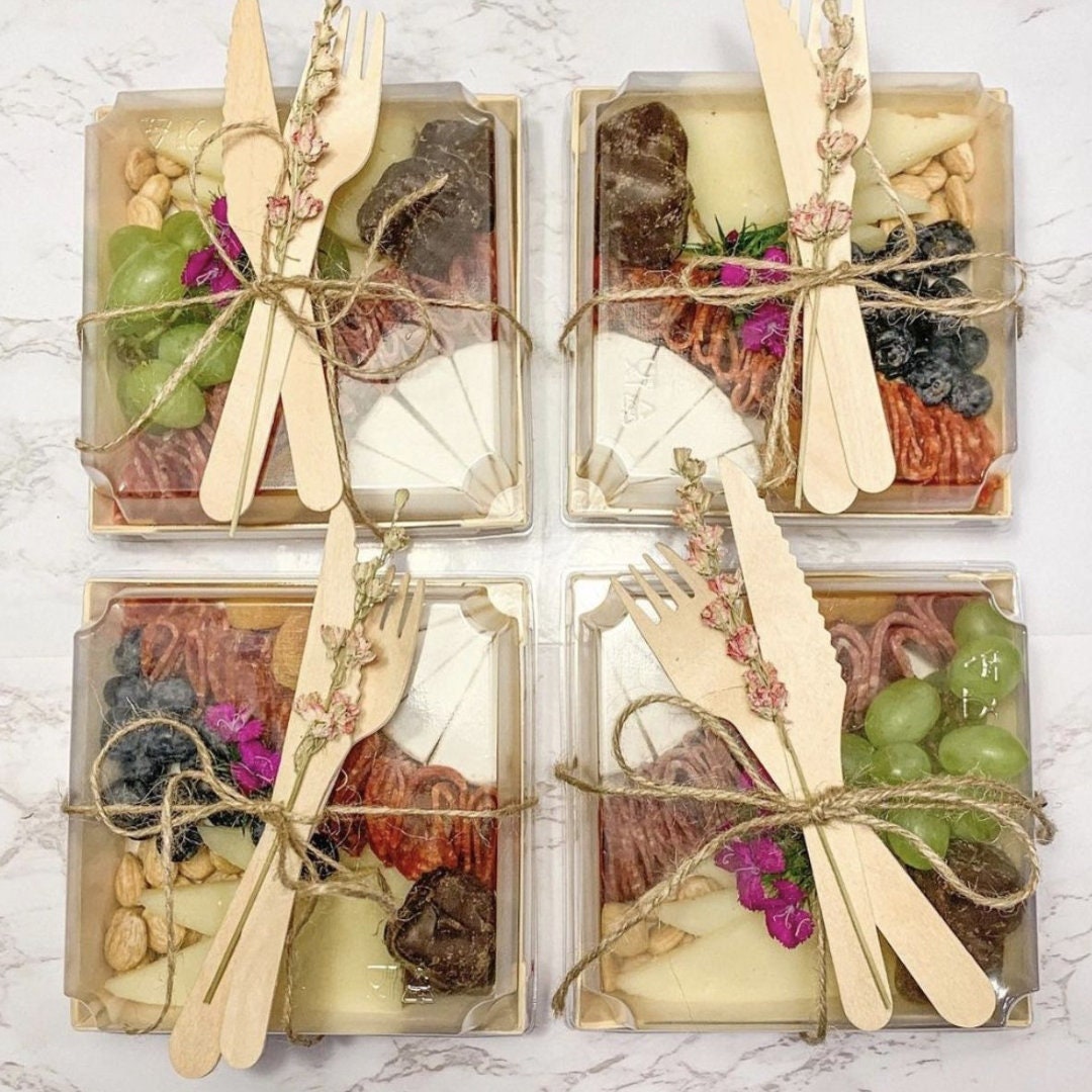 Four square charcuterie favor boxes with rustic twine ties and mini wooden forks for weddings