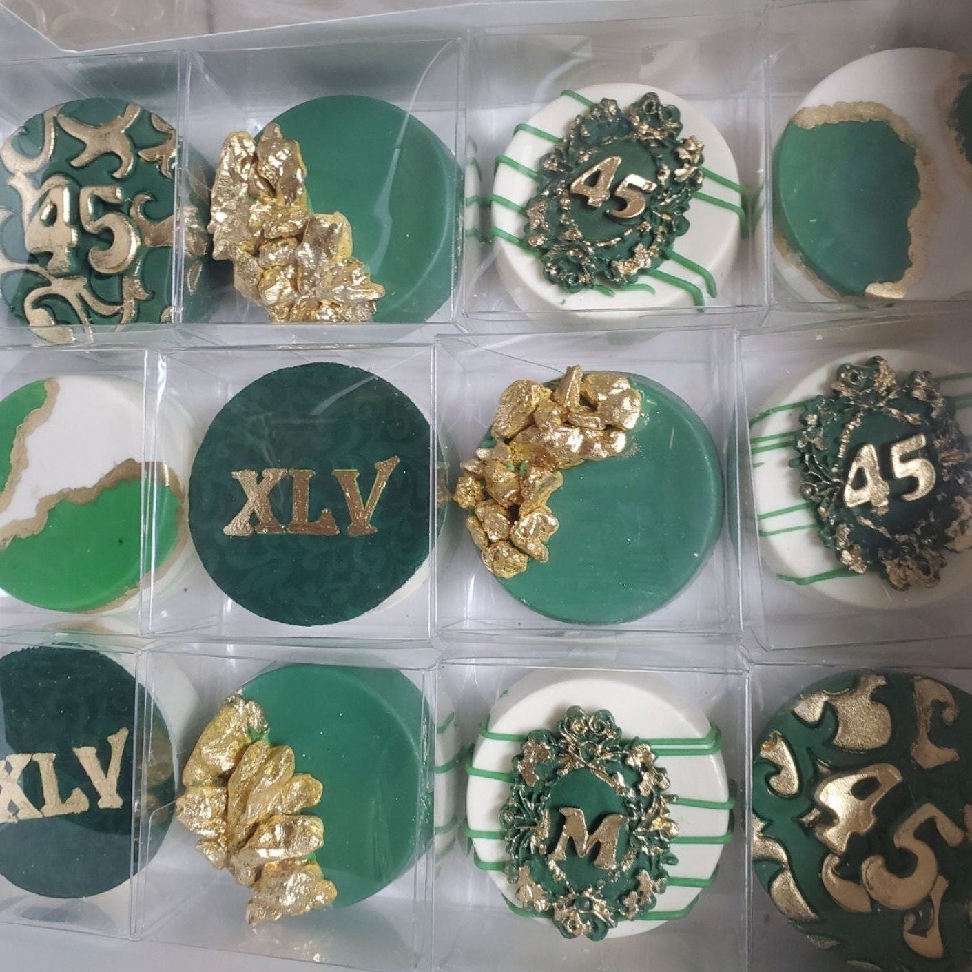 Grid of green and gold themed Oreos packaged in individual clear boxes
