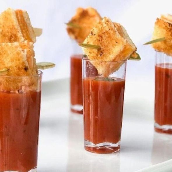 Tomato soup served in crystal-clear mini acrylic cups, angled view, highlighting the elegant presentation and polished acrylic material.