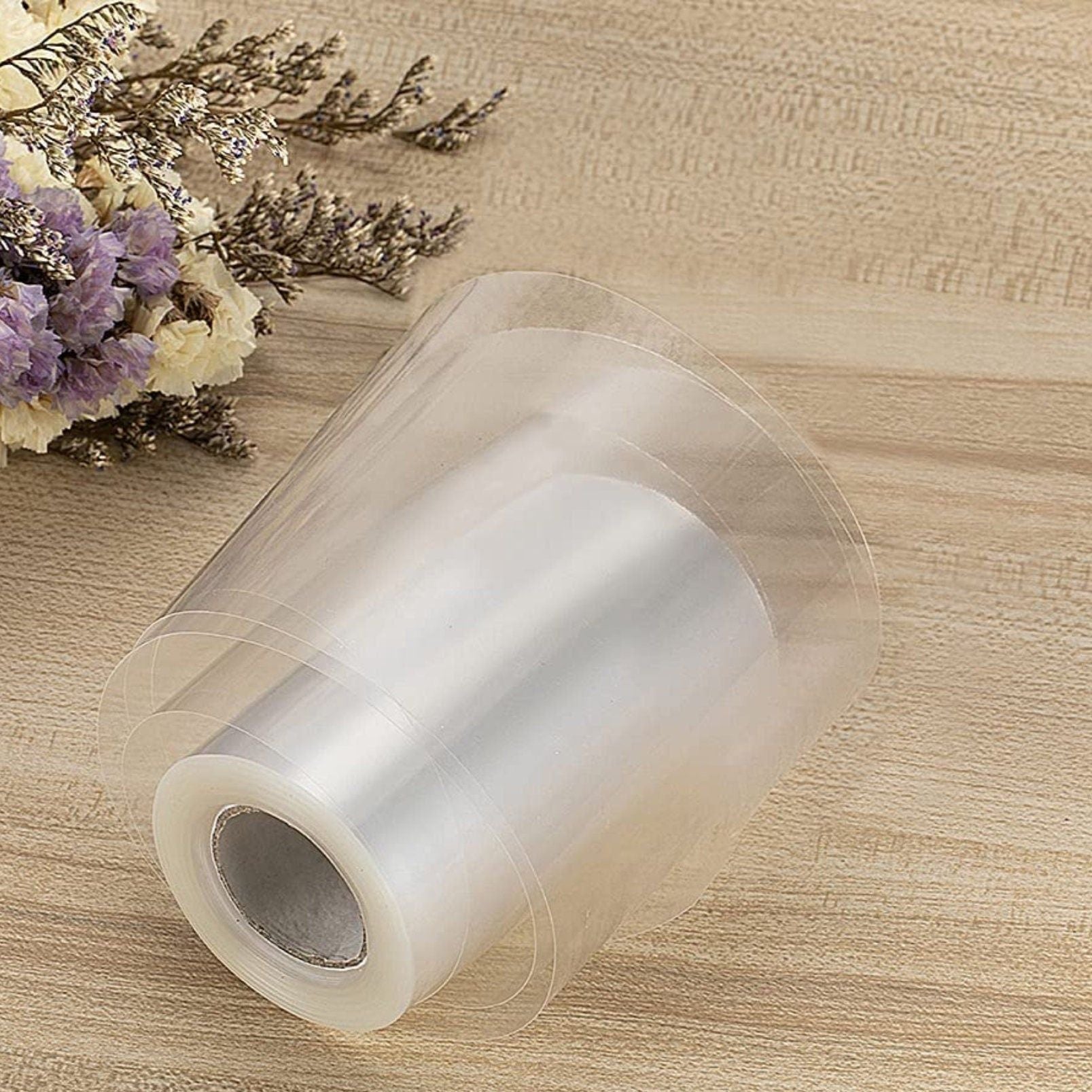 Close-up of transparent sticker securely sealing a plastic cake wrap around a fresh mini cake.