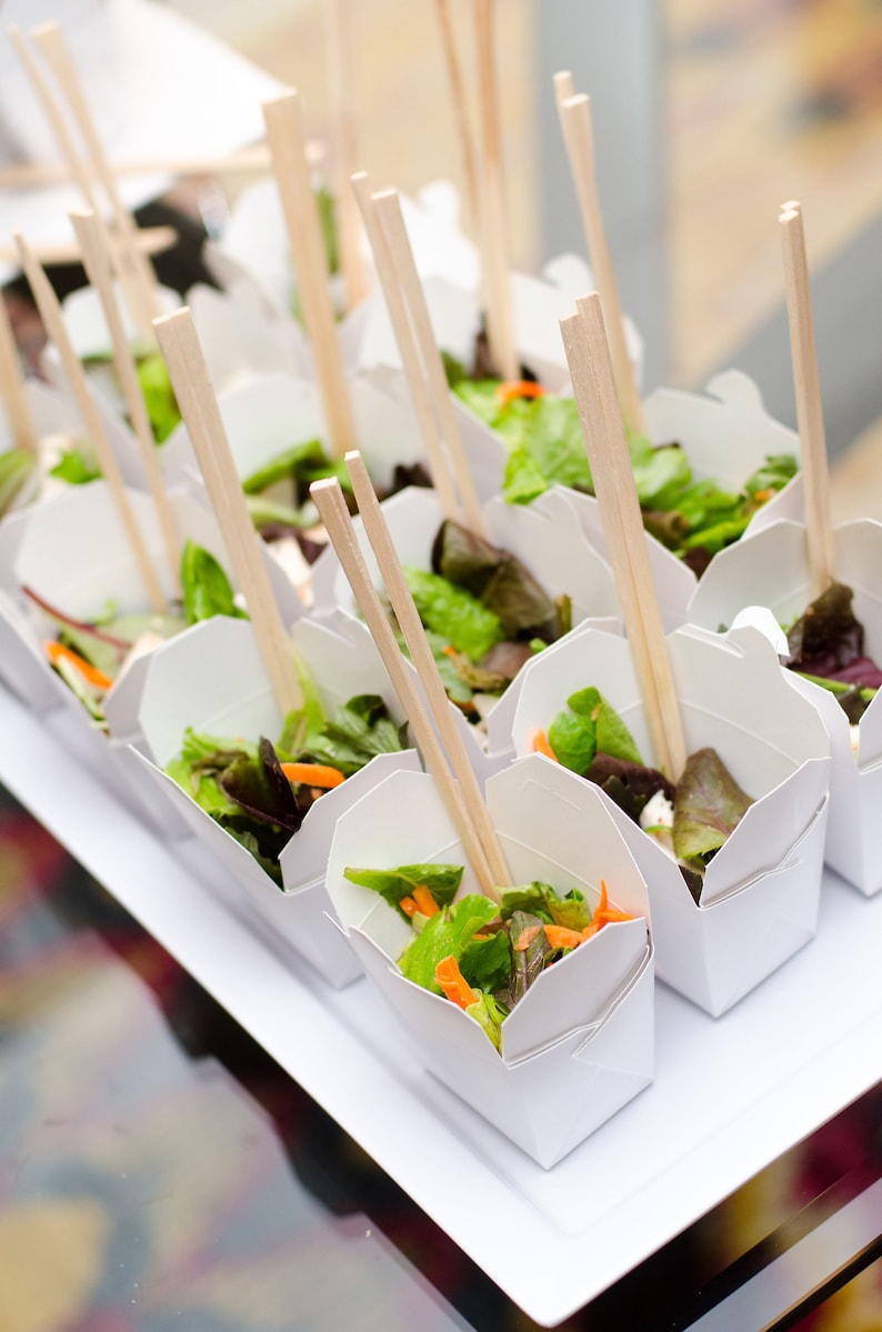 White Chinese food boxes with wooden chopsticks disposable for themed parties.