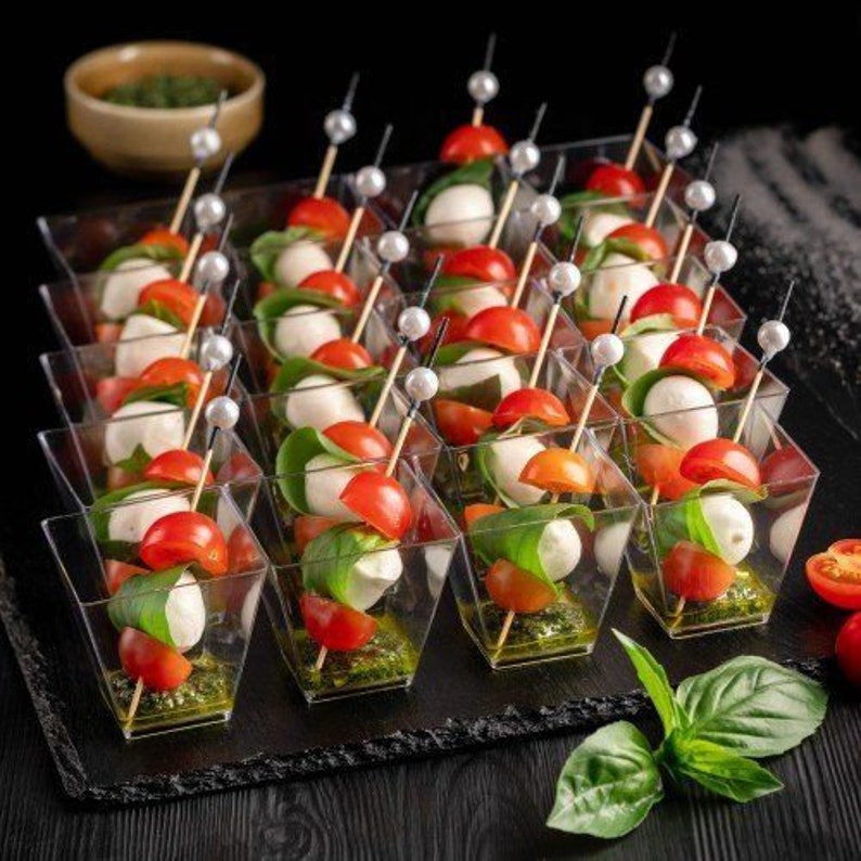 Clear acrylic charcuterie cup with gold fancy toothpick on a grazing table