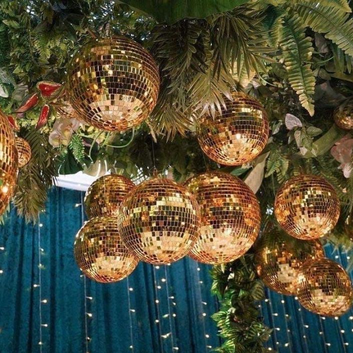 Assortment of gold disco mirror balls, elegantly displayed in various sizes, perfect for upscale disco party decorations.