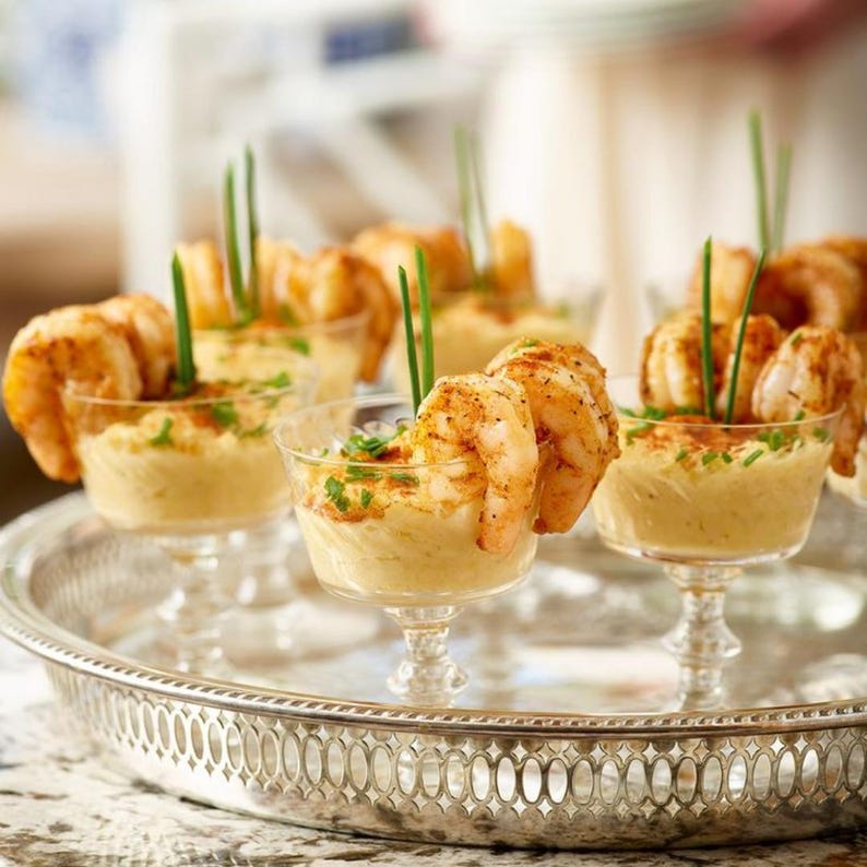Tray of mini martini plastic glasses filled with delicious shrimp cocktail appetizers for elegant party catering events.