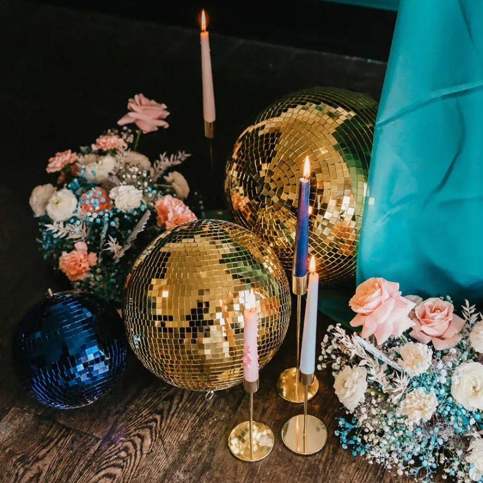 Collection of mirror balls in gold, including various sizes up to 4 inches, ready to elevate any party with disco-themed elegance.