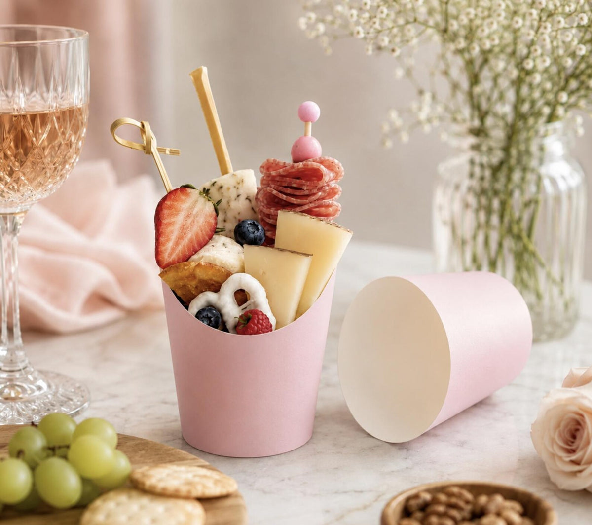 Disposable wooden charcuterie cups with various cheeses, meats, and crackers. Eco-friendly appetizer cones.