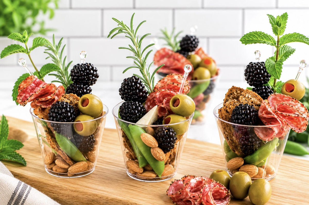 Close-up of charcuterie cup with meat, cheese, and crackers. Individual disposable wooden cone for catering.