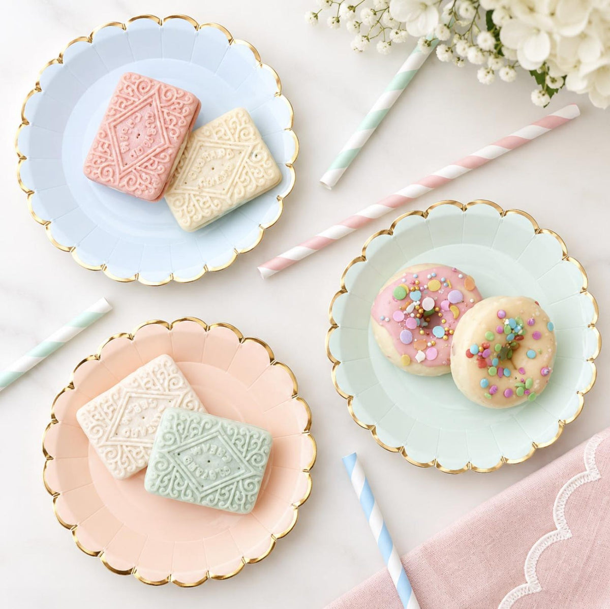 Pastel scalloped paper party plates with gold trim in blue, pink and mint for birthdays and baby showers