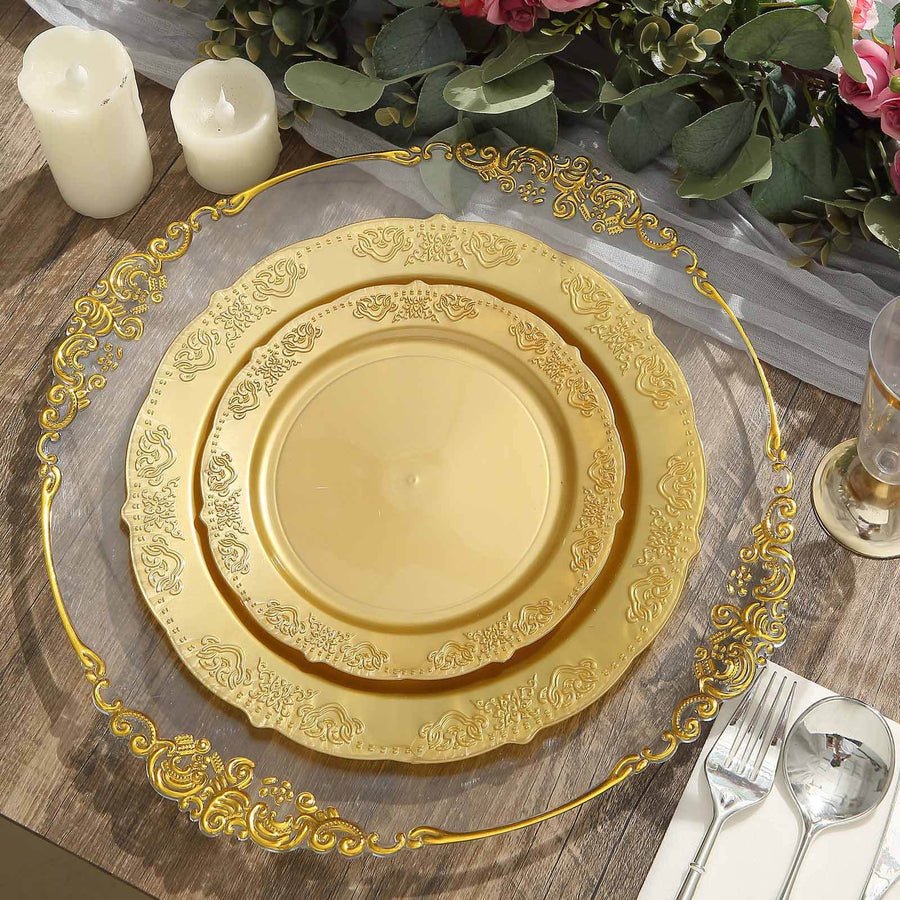 White plastic dinner plate with gold baroque rim, set with elegant gold cutlery. Disposable party tableware.