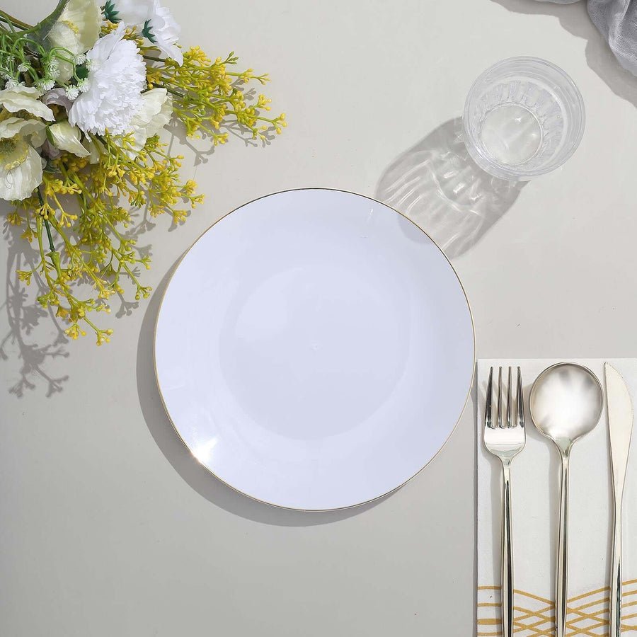 Ivory hammered plastic dinner plate with gold rim and gold cutlery. Disposable tableware set.