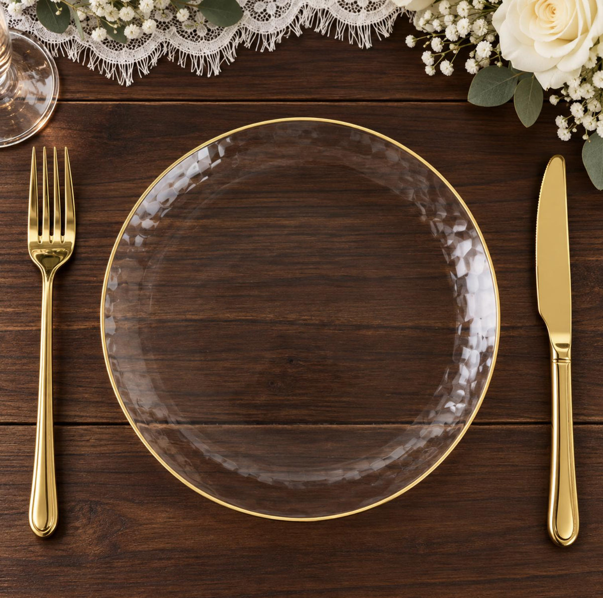 Ivory hammered plastic dinner plate with gold rim and gold cutlery. Disposable tableware set.