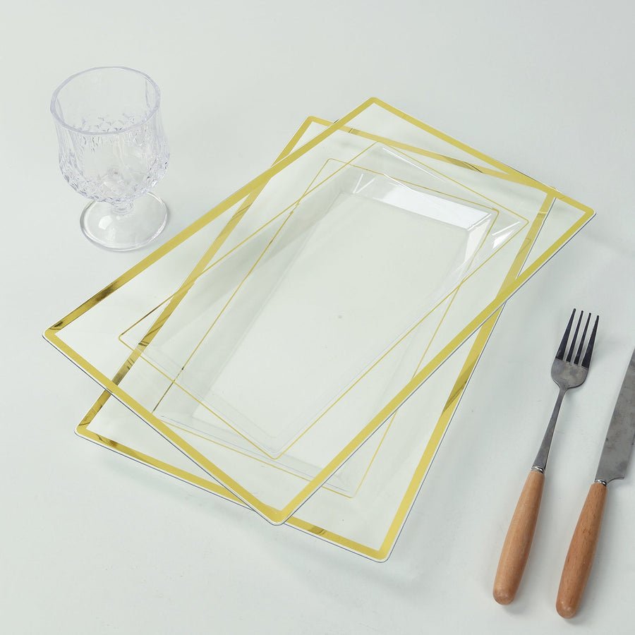 Set of clear rectangular plastic serving trays with gold rim beside cutlery and glass