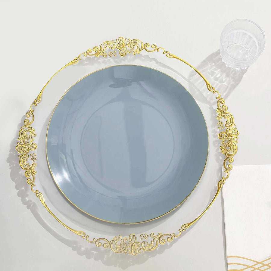 Clear baroque charger plate with ornate gold rim, set with glossy gold plastic plates. Disposable event tableware.