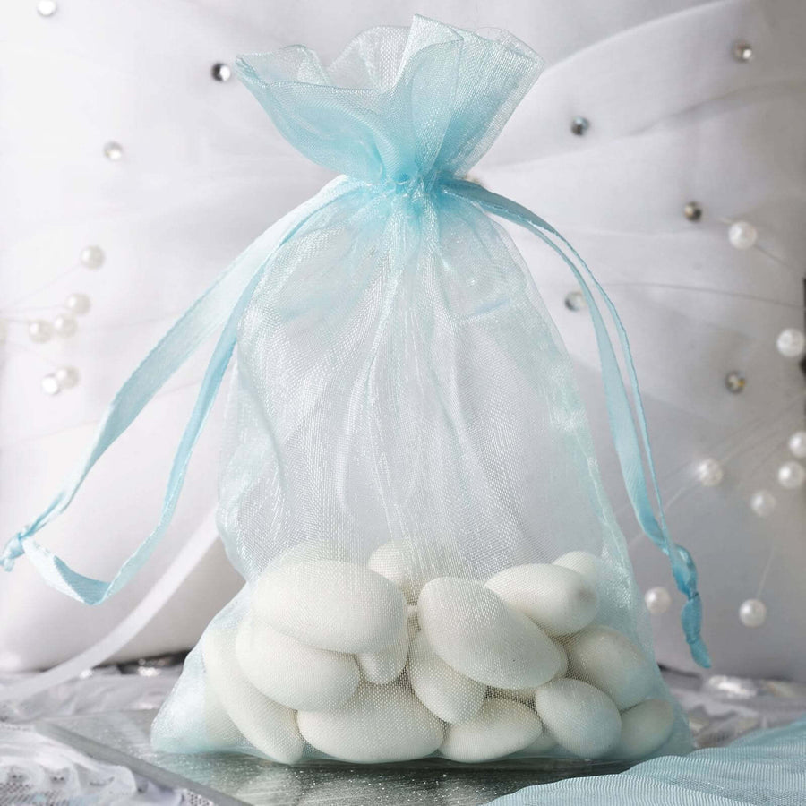 Light blue organza drawstring gift bag filled with white almonds – elegant 4"x6" favor pouch for weddings and special events
