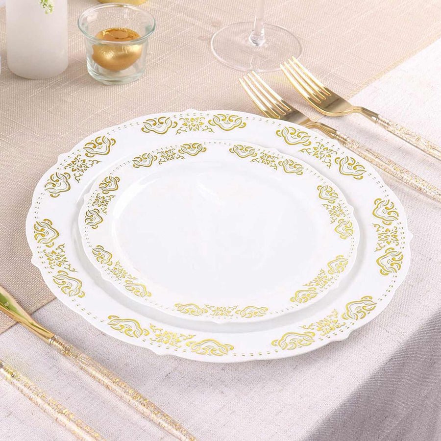 White plastic dinner plate with ornate gold baroque rim and gold cutlery. Disposable wedding set.