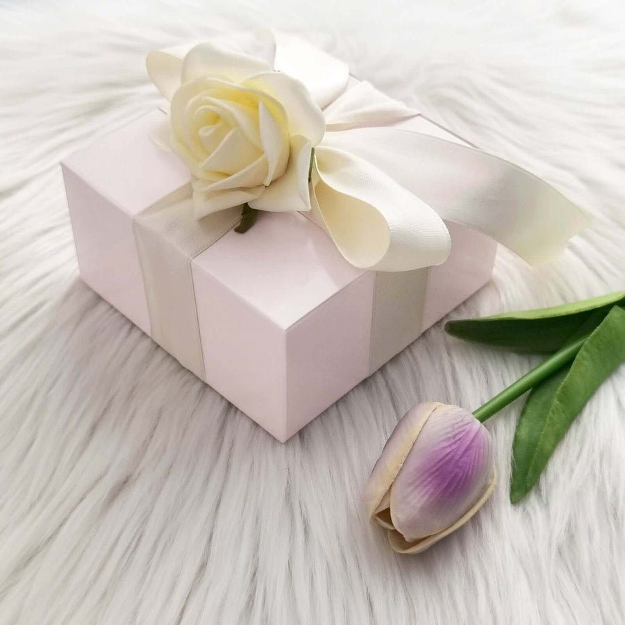 Gold metallic favor box with white ribbon & rose. Glamorous gift packaging for wedding favors.