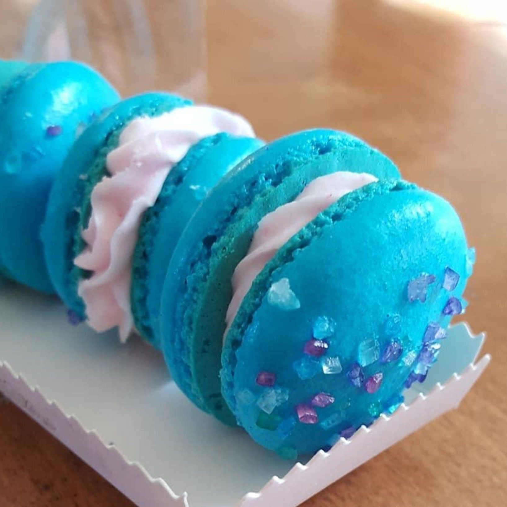 White scalloped tray with oversized blue macarons sized for white box