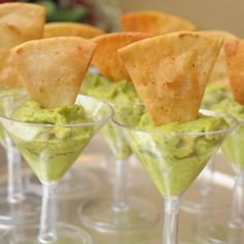 Clear acrylic martini appetizer cup filled with guacamole and tortilla chip