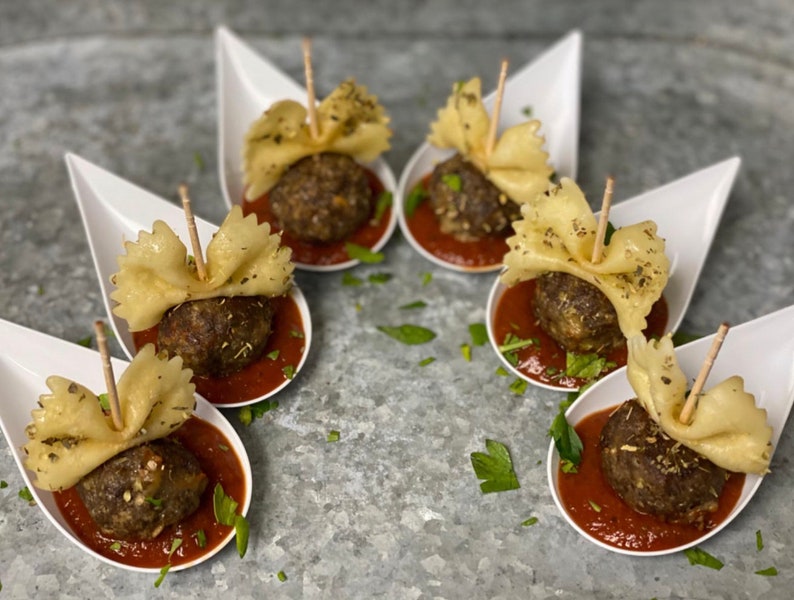 Round galvanized tray with Asian spoons holding meatballs and fried bites around sauce.